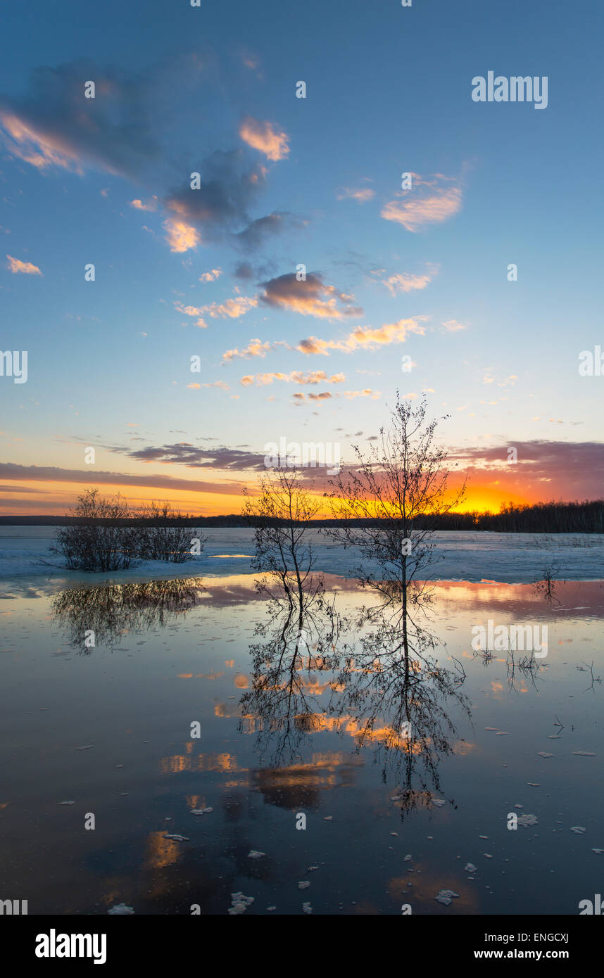 Ein See bei Sonnenuntergang. Eis schmilzt auf der Oberfläche des Wassers. Stockfoto
