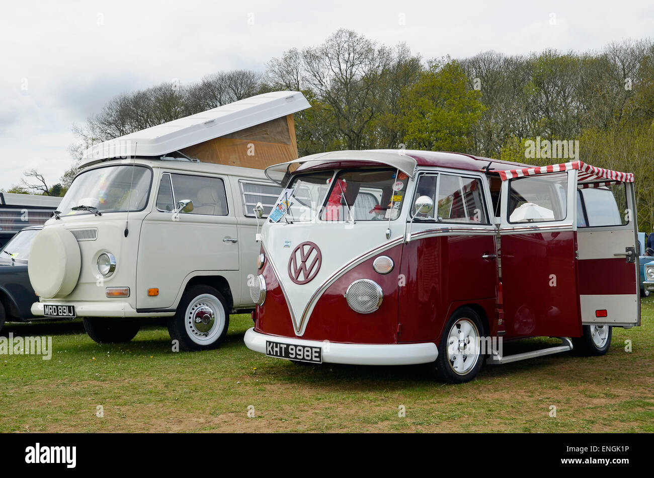 Volkswagen Wohnmobile aus zwei verschiedenen Epochen - eine geteilte Windschutzscheibe aus den 1950er Jahren und ein Erker aus den späten 1960er Jahren. Stockfoto