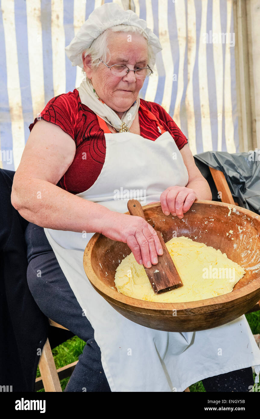 Eine alte irische Dame nutzt eine Paddel zur Hand-bilden Sie Butter. Stockfoto