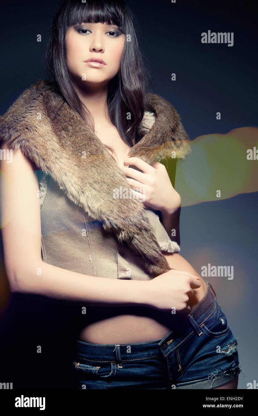 Mode-Portrait von junge asiatische Frau in einem Pelz getrimmt Gilet und Denim shorts Stockfoto