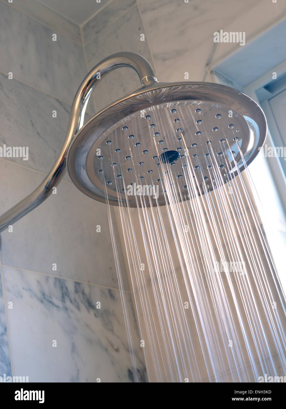 Luxuriöser „Monsoon“-Duschkopf mit sonnendurchflutetem Wasser im Marmorbad Stockfoto