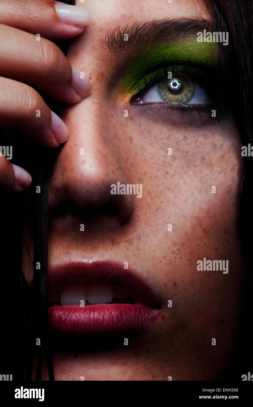 Schönheit in Nahaufnahme sommersprossige junge Frau mit bunten Augen Make-up beschnitten Stockfoto