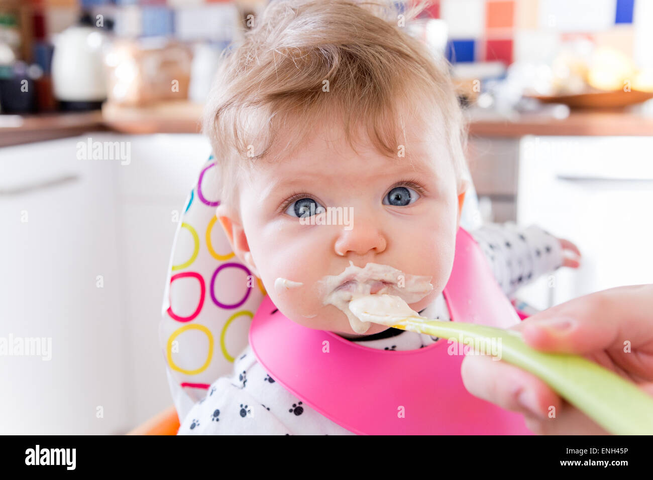 Sechs Monate altes Baby Mädchen Löffel Fütterung auf Brei Stockfoto