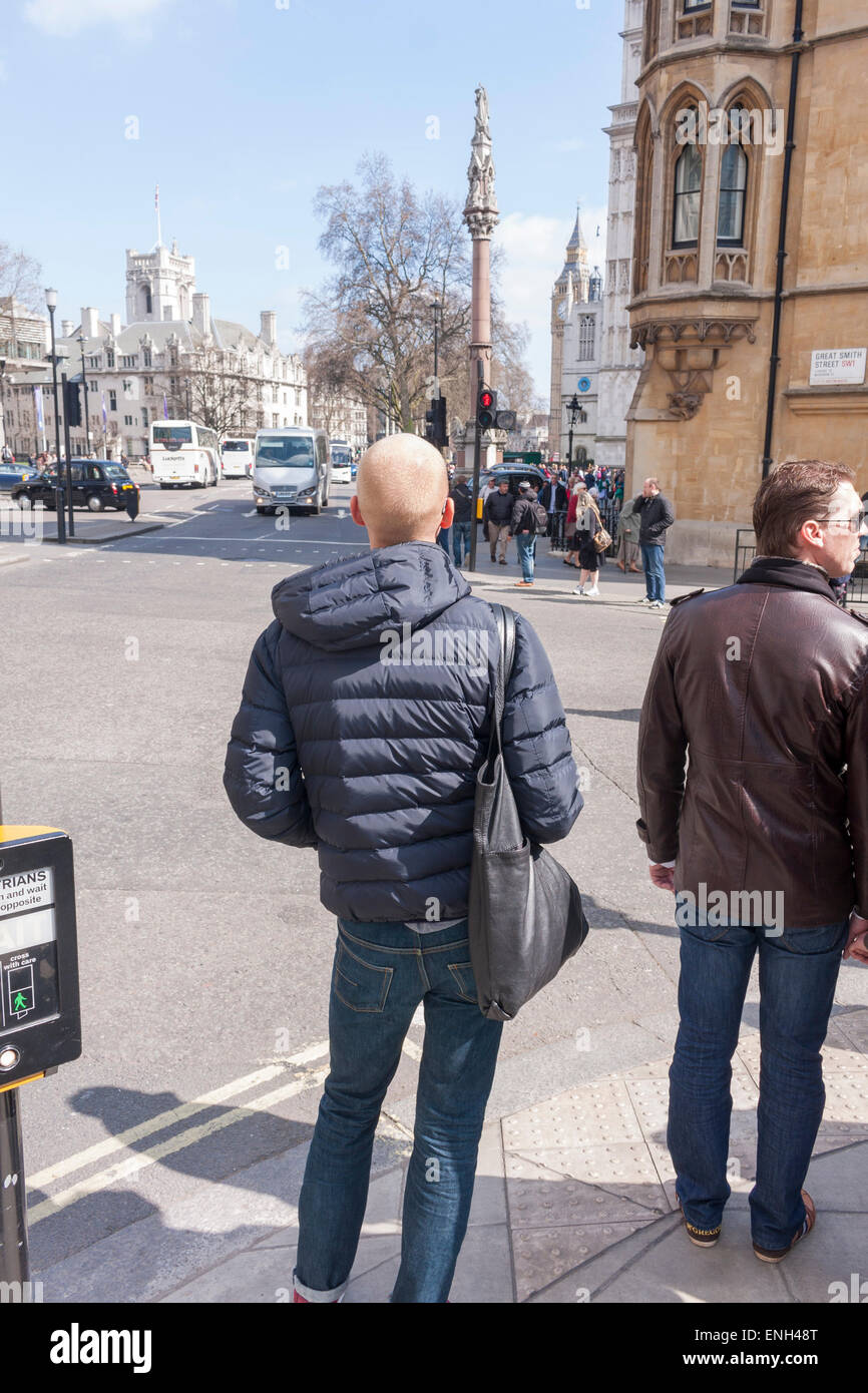 Zwei männliche Fußgänger stehen warten auf die Straße zu überqueren Stockfoto