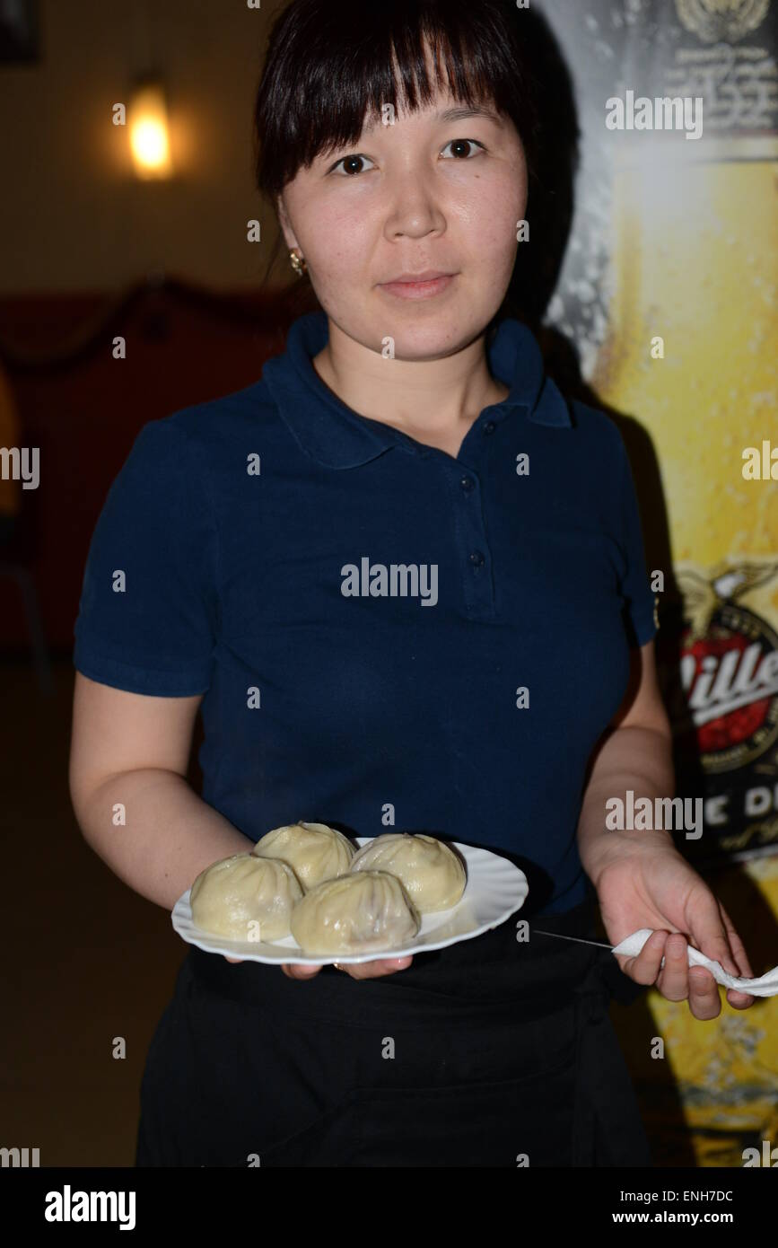Eine burjatische Frau Buuzy (auch bekannt als Pozy) - eine traditionelle Fleisch-Knödel serviert. Stockfoto