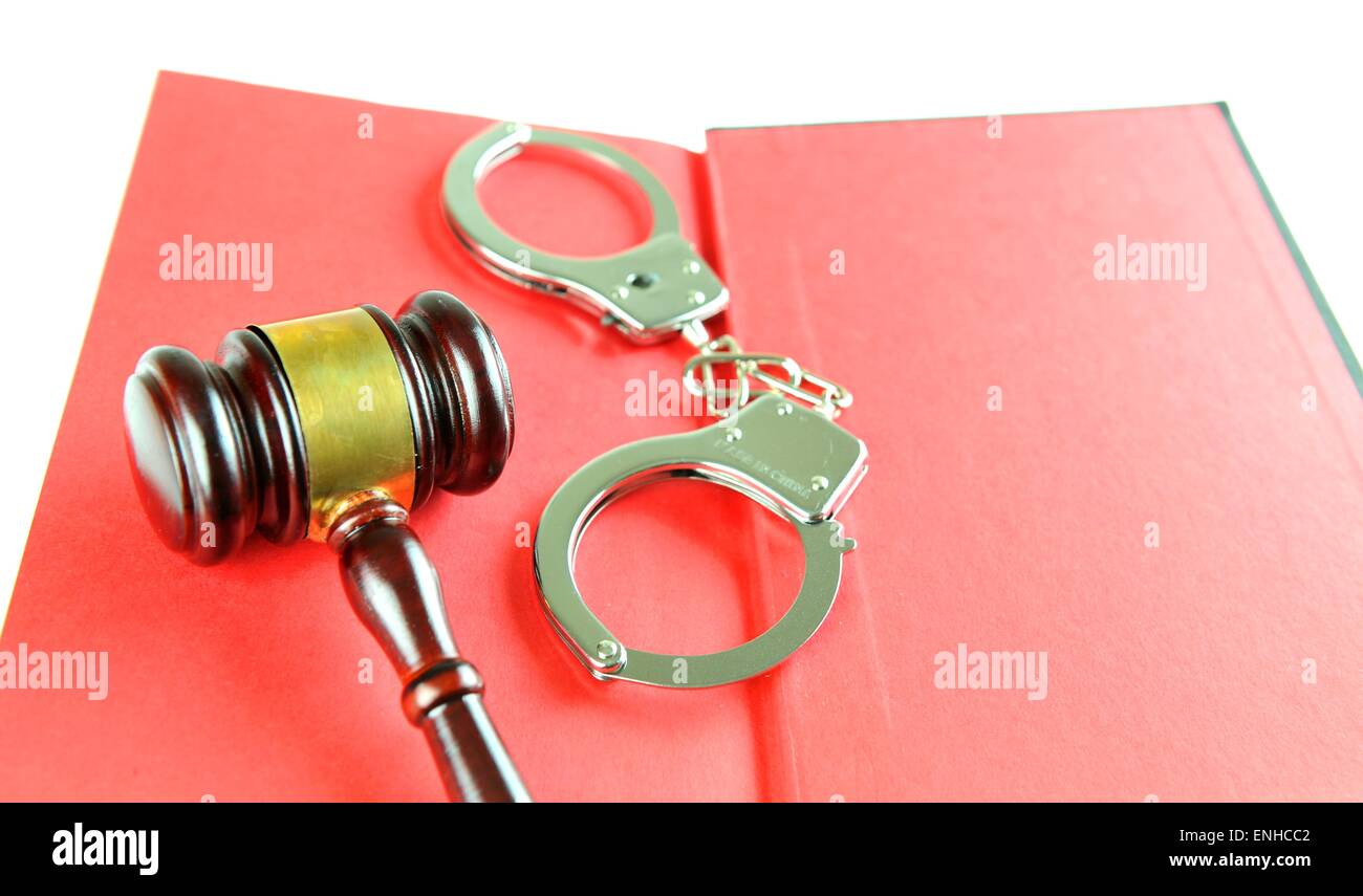 Begriff mit Hammer und Handschellen gegen rote Buch Stockfoto