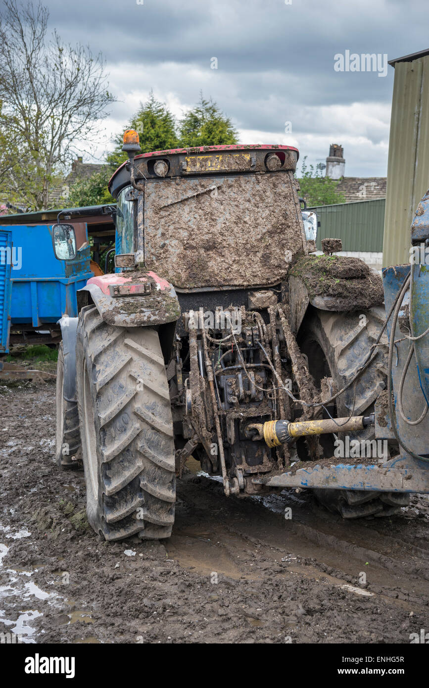 Traktor über im Schlamm nach Dreck verbreiten. Stehend in den schlammigen Boden in einem englischen Hof. Stockfoto