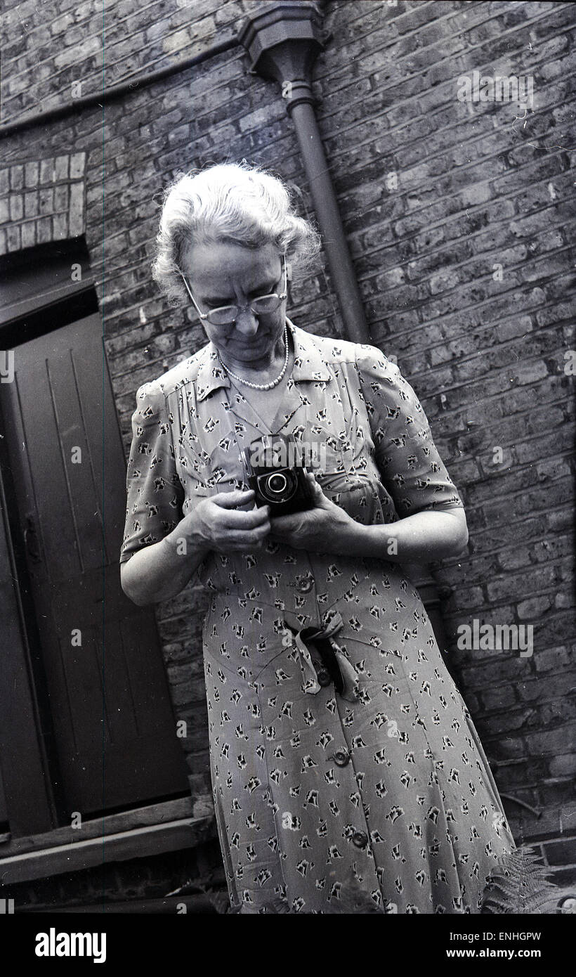 historische, 1940er Jahre, ältere Dame außerhalb mit einer zweiäugigen Spiegelreflexkamera. Stockfoto