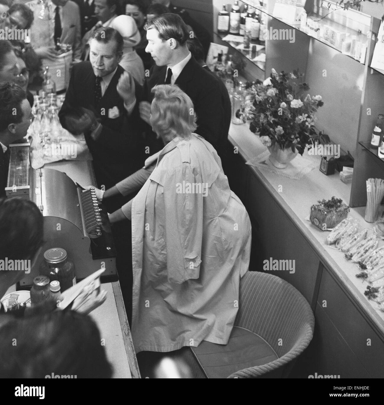 US-amerikanische Schauspielerin Marilyn Monroe und Sir Laurence Olivier Zuflucht von den wartenden Fotografen hinter einem Schalter am Flughafen Heathrow. Monroe hatte gerade mit ihrem Mann, Dramatiker Arthur Miller und Vivien Leigh in London geflogen. Marilyn ist hier zu fil Stockfoto