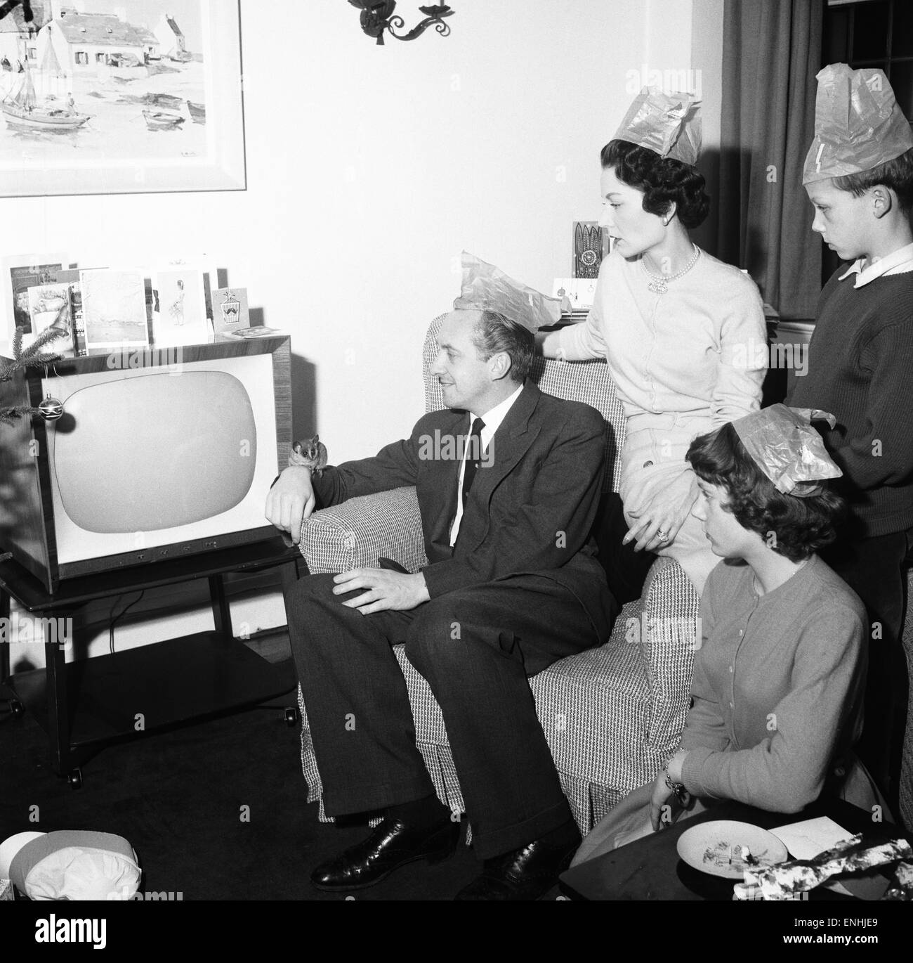 TV-Moderatorin Hughie Green gesehen hier zu Hause zu Weihnachten mit seiner Familie. Von links nach rechts Hughie Green, Frau Claire, Tochter Linda und Sohn Christopher. Die Bush-Babysitting auf Hughies Arm war ein Weihnachtsgeschenk für seinen Sohn. 27. Dezember 1957 Stockfoto