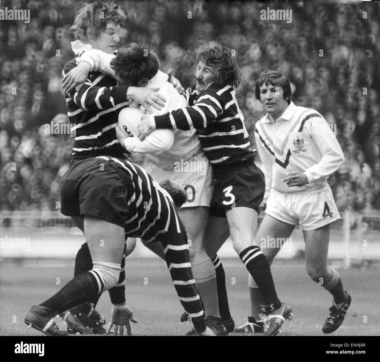 Warrington Brady ist umgeben aber unerschrocken, wird bestimmt nicht zu den Ball an die drei Featherstone Rovers Spieler während der Rugby-League-Cup-Finale ergeben. 11. Mai 1974 Stockfoto