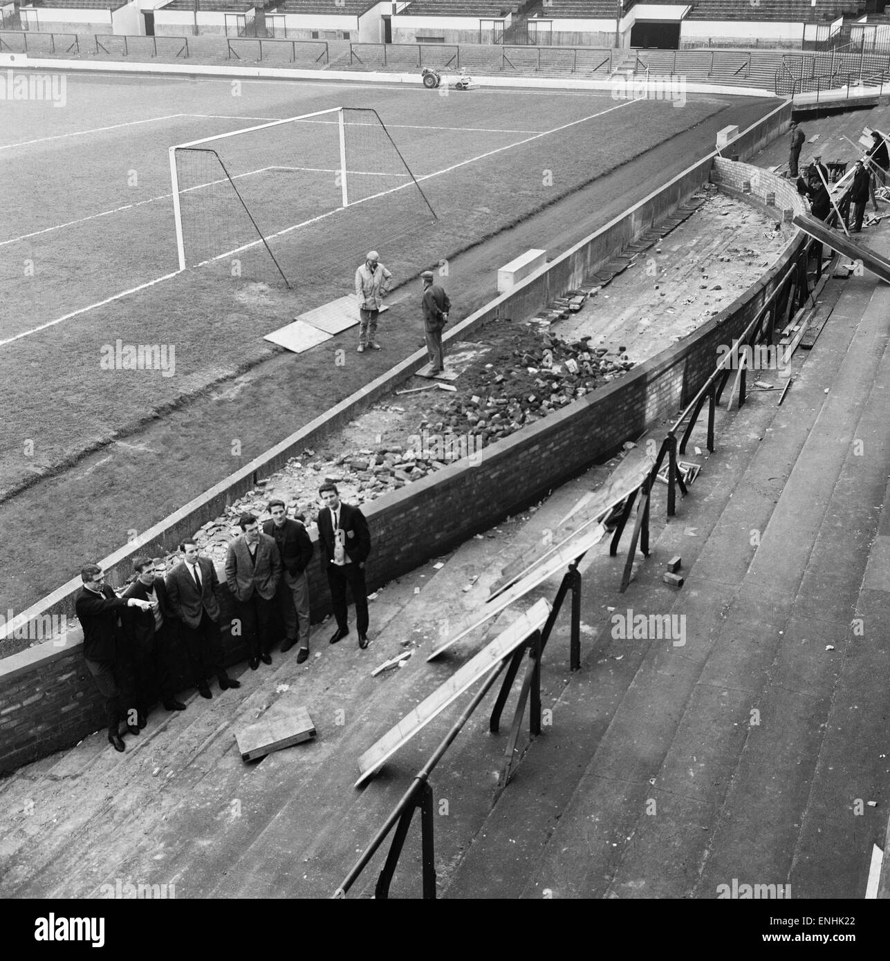 Barrikaden fallen und eine Mauer ist im Goodison Park, Heimat des FC Everton Football Club, in Vorbereitung auf die WM 1966 errichtet. Everton-Spieler beobachten Arbeiter sind Brian Labone, Gordon West, Mick Meagan, Dennis Stevens, Derek Temple und Alex Parker. 1 Stockfoto