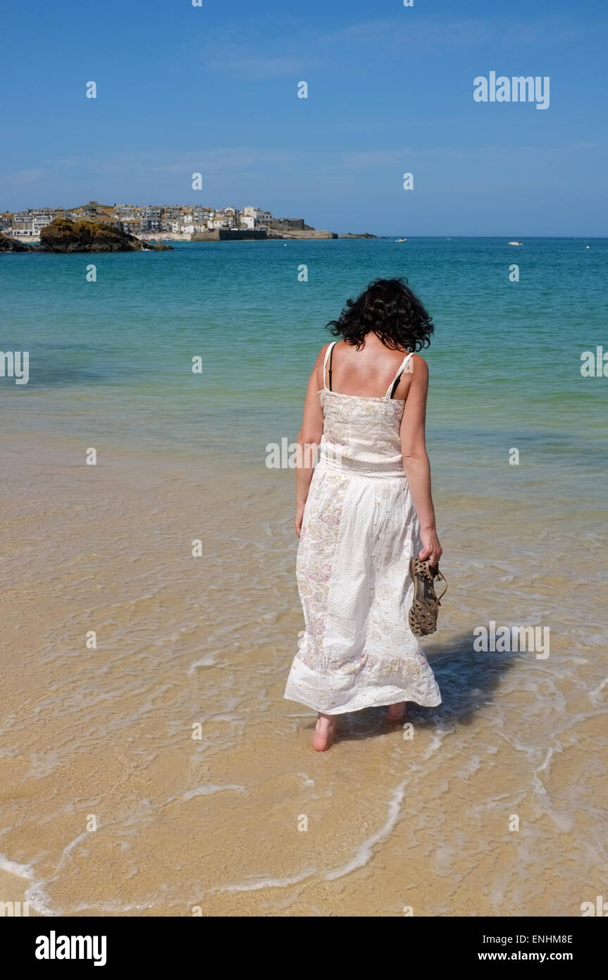 St Ives, Cornwall: Frau im Sommerkleid zu Fuß entlang des Wassers auf Porthminster Beach in St Ives auf der Cornwall Stockfoto
