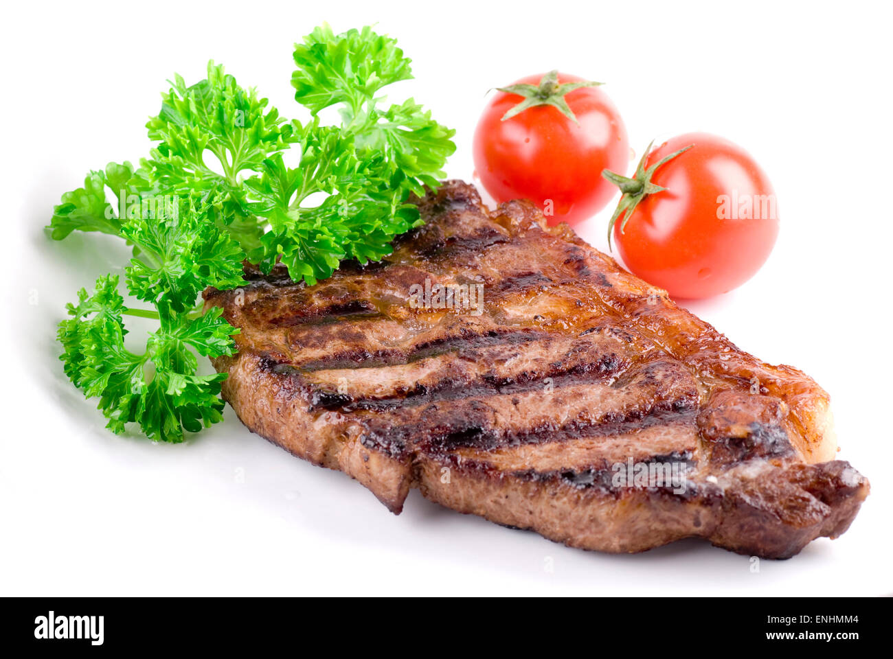 Gegrilltes Steak mit frischer Petersilie auf weißen Teller. Stockfoto