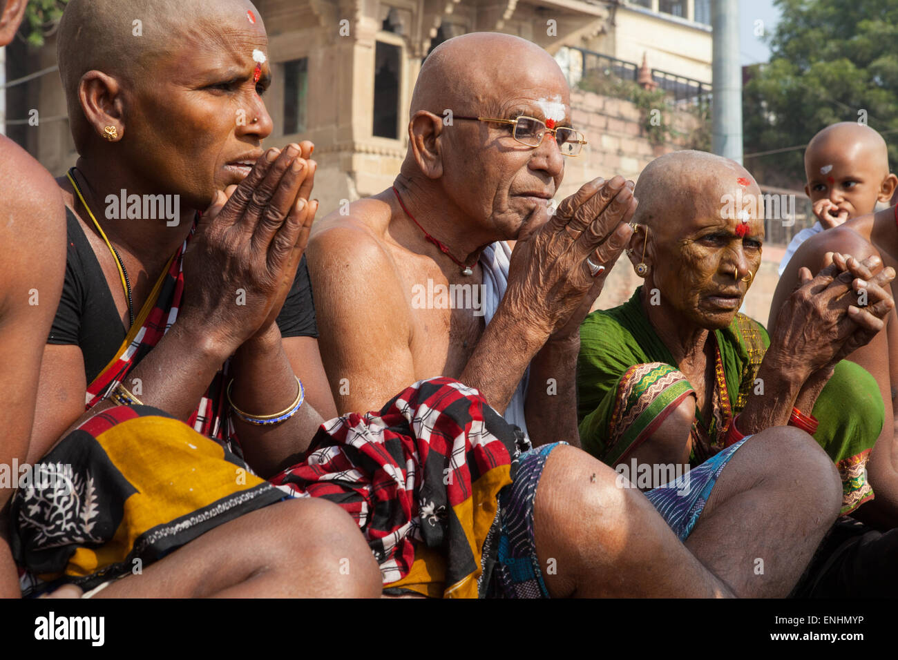 Eine trauernde Familie, die einen verstorbenen Verwandten eingeäschert haben führen Puja an den Ghats in Varanasi Stockfoto