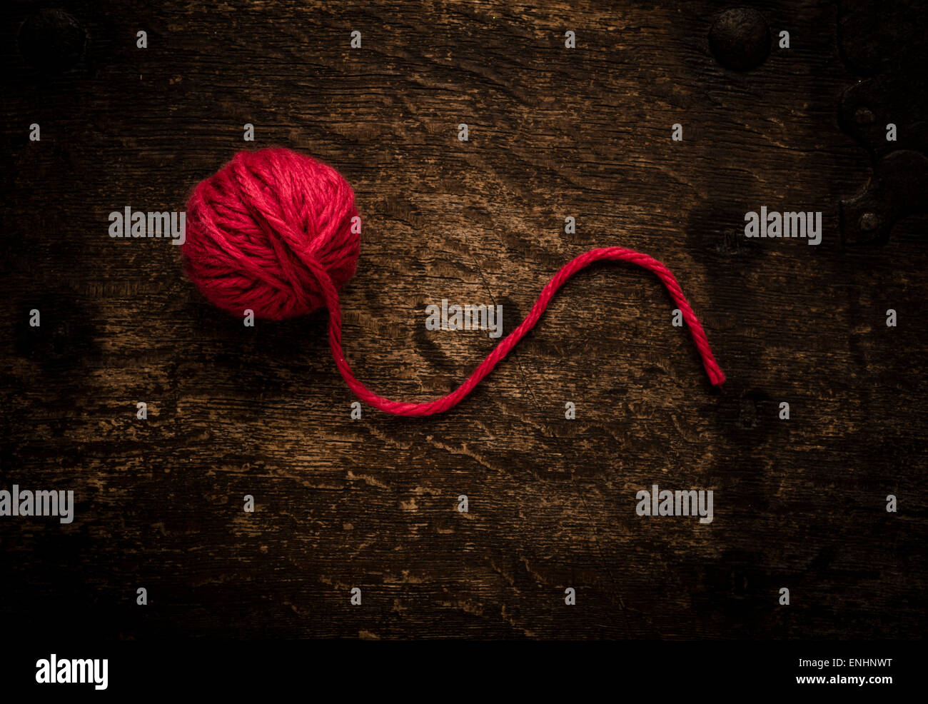 Stillleben mit roten Wollknäuel auf Holztisch. Konzeptbild von stricken oder häkeln. Stockfoto