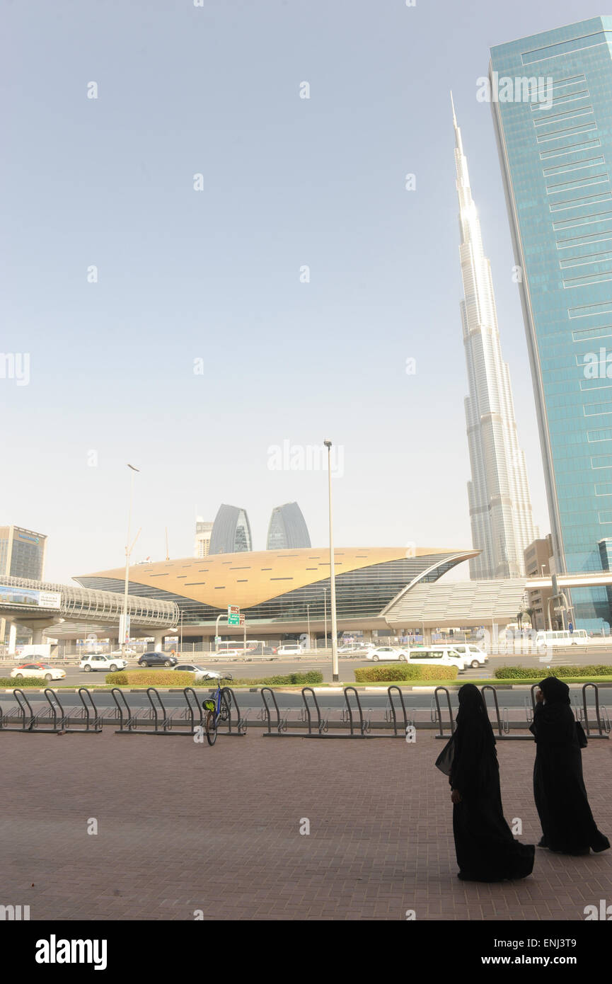 Zwei emiratischen Frauen entlang der Sheikh Zeyad Straße mit u-Bahnstation und Burj al Khaliefeh im Hintergrund. Stockfoto