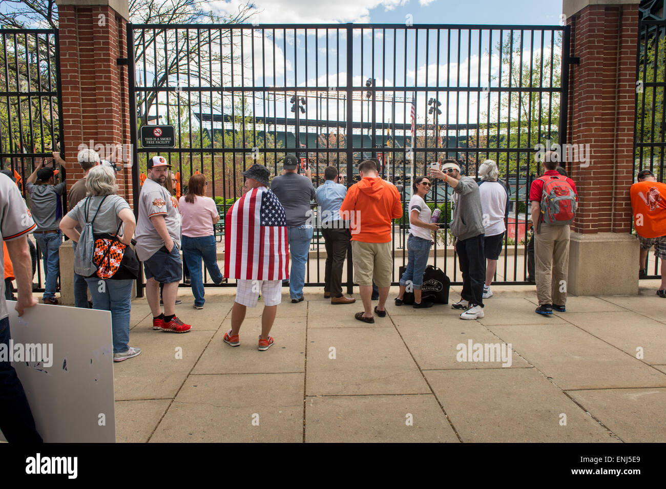 Baltimore Oriole Fans das Spiel von außerhalb von Camden Yards durch die breite Stadtbefehl, die Events und Veranstaltungen für die Öffentlichkeit geschlossen werden während Baltimore in einen Ausnahmezustand waren nach der Tod von Freddie Gray führte zu Stadt große Unruhen und Proteste beobachten. Stockfoto