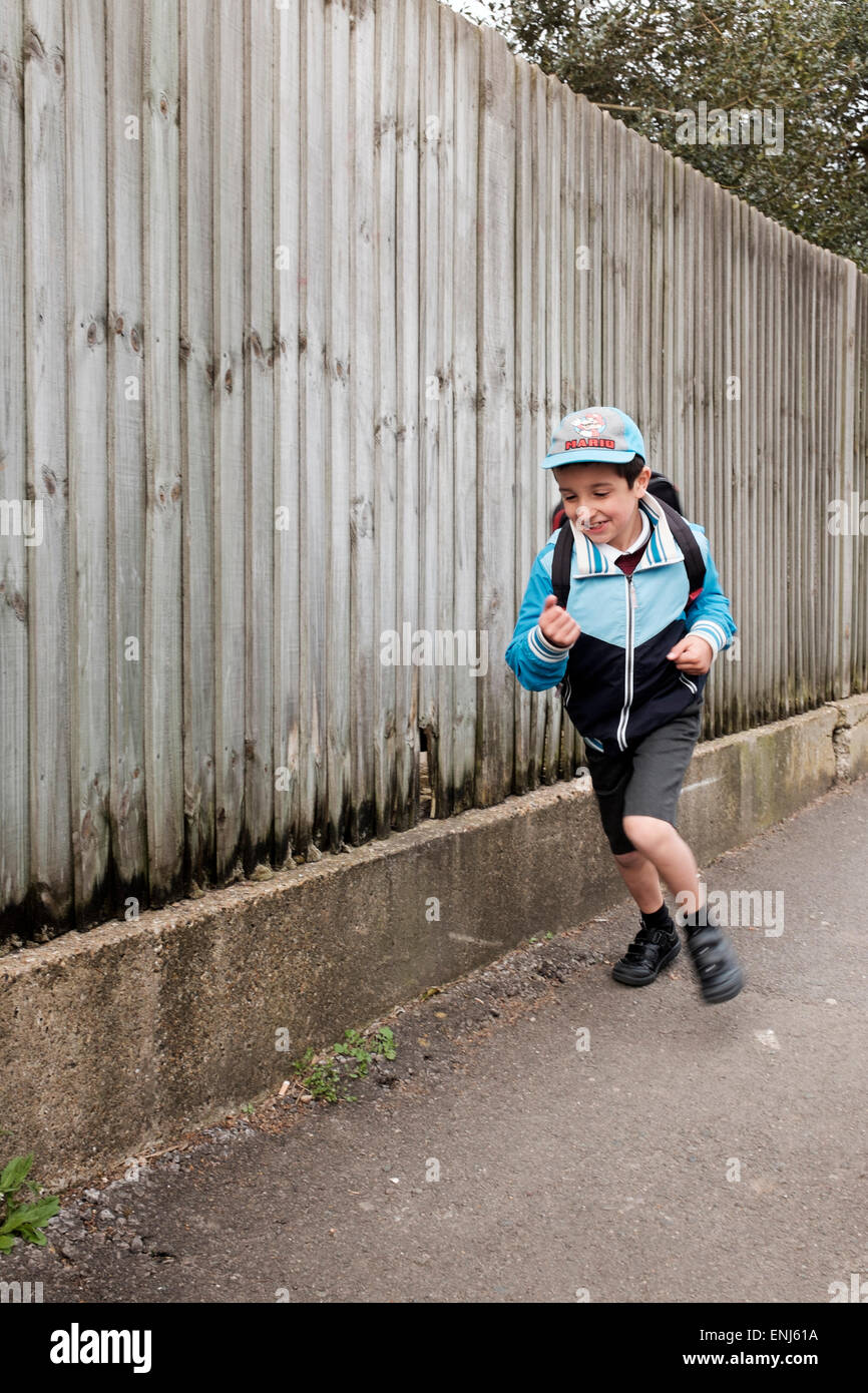 Primäre Schuljunge, laufen nach Hause nach der Schule, Surrey, UK Stockfoto