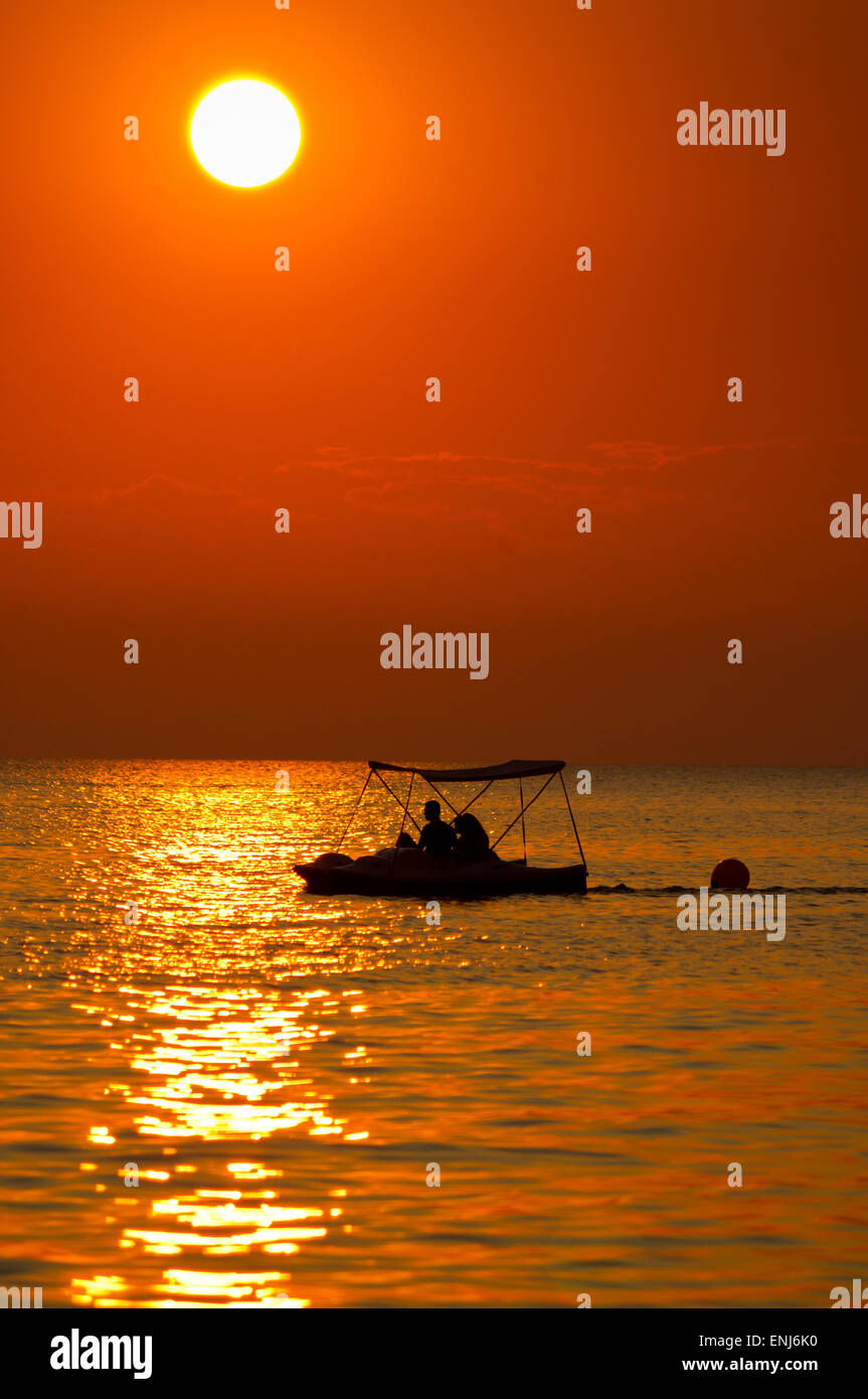 Schönes Paar Reiten ein Tretboot auf dem Meer bei Sonnenuntergang Stockfoto