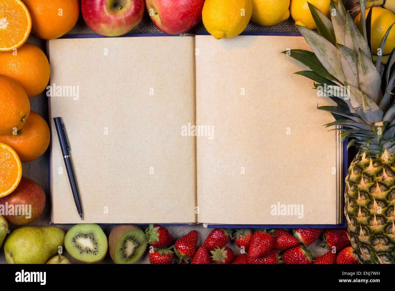 Auswahl an frischen Früchten mit einer offenen Rezeptbuch - leere Seiten - Platz für Text Stockfoto