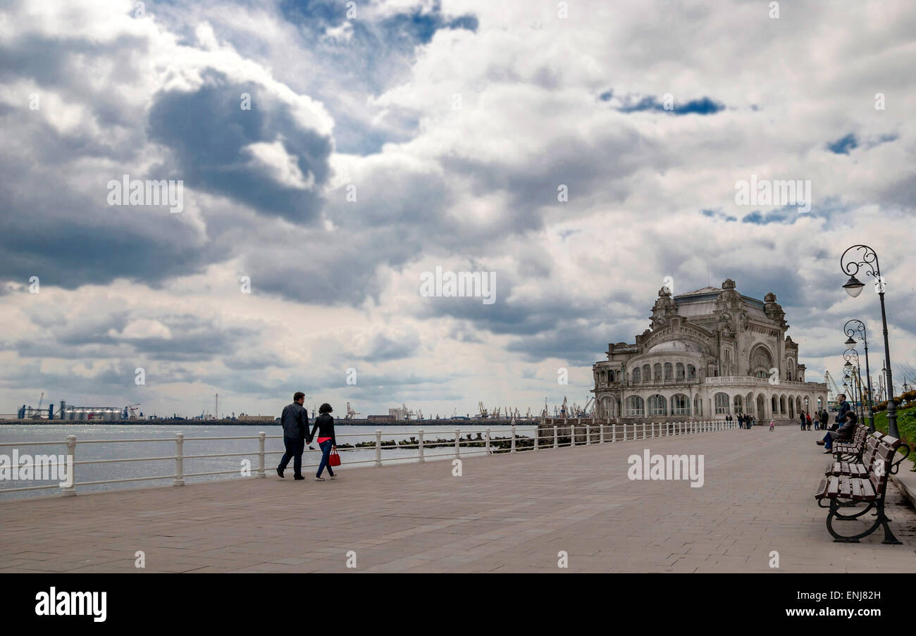 Paar zu Fuß entlang dem Schwarzen Meer an der Promenade von Constanta. Im Hintergrund ist altes Casino, berühmte Gebäude, Wahrzeichen der Stadt Stockfoto