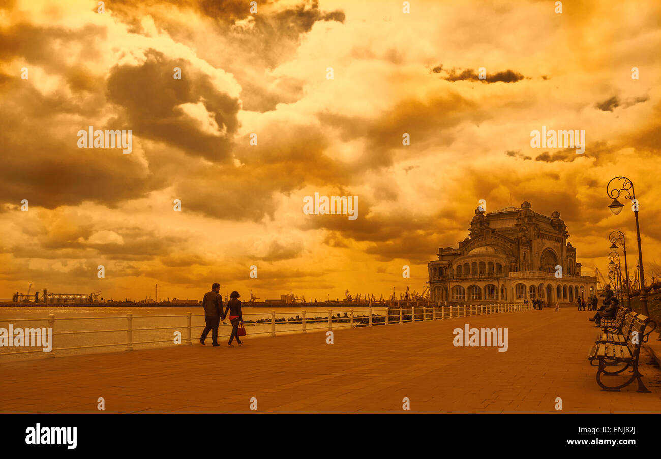 Paar zu Fuß entlang dem Schwarzen Meer an der Promenade von Constanta. Im Hintergrund ist altes Casino, berühmte Gebäude, Wahrzeichen der Stadt Stockfoto