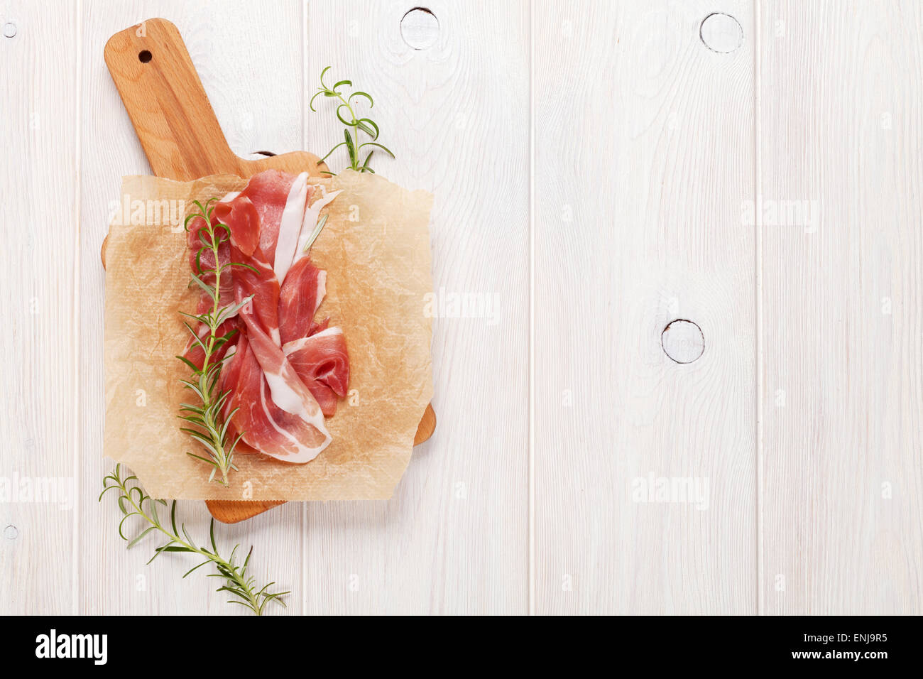 Prosciutto mit Rosmarin auf Schneidebrett. Draufsicht mit Textfreiraum Stockfoto