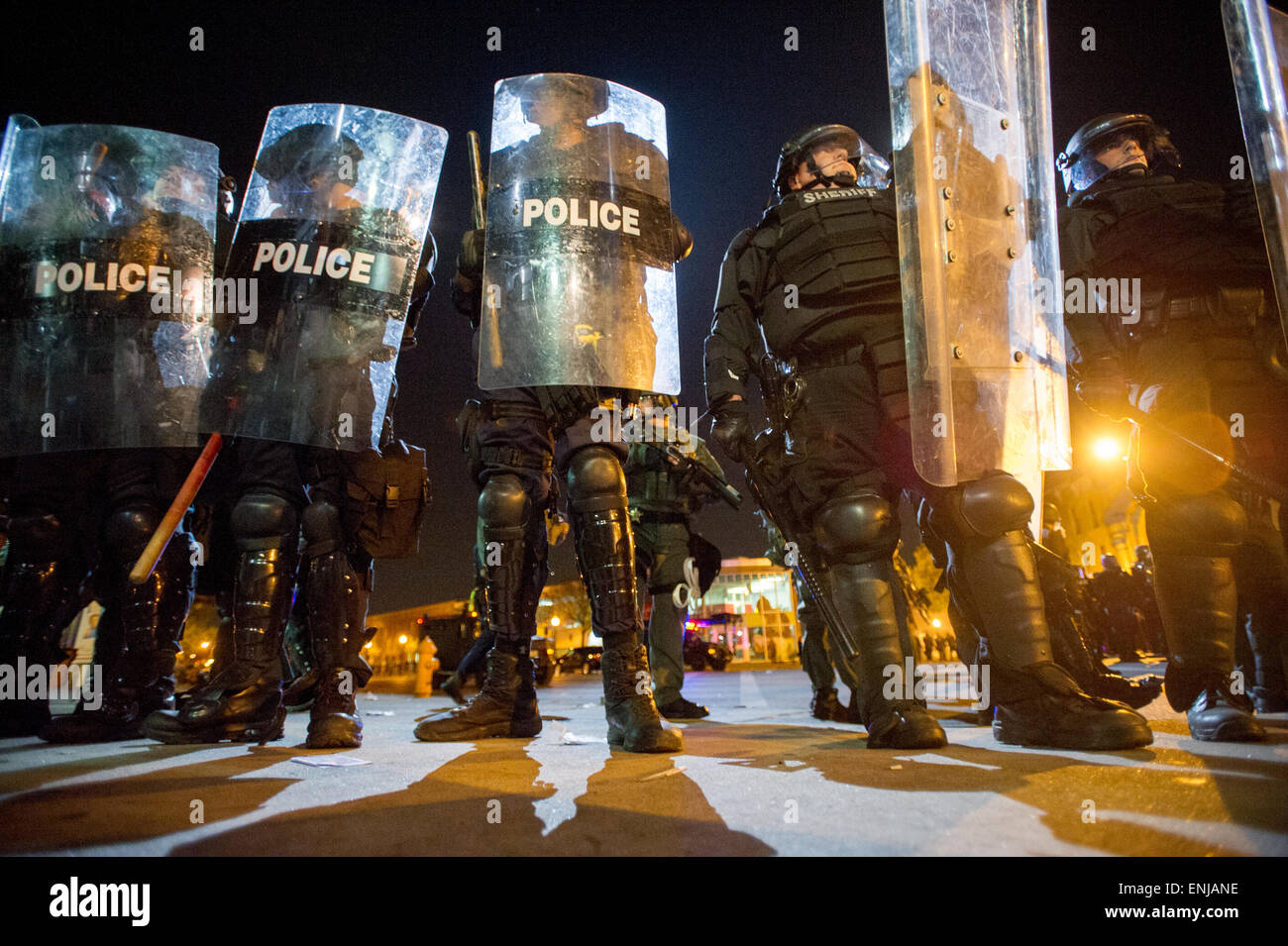 Nach der Cop im Zusammenhang mit Tod von Freddie Gray, brach West Baltimore Unruhen und Proteste, die Aufmerksamkeit auf die Brutalität der Polizei im Baltimore Police Department zu bringen versucht. Hier, riot zusammen mit einer Gruppe von Demonstranten nach Pennsylvania und North Avenue in West Baltimore einberufen, Polizei warten, bewaffnet, um 22:00 Ausgangssperre durchzusetzen. Stockfoto