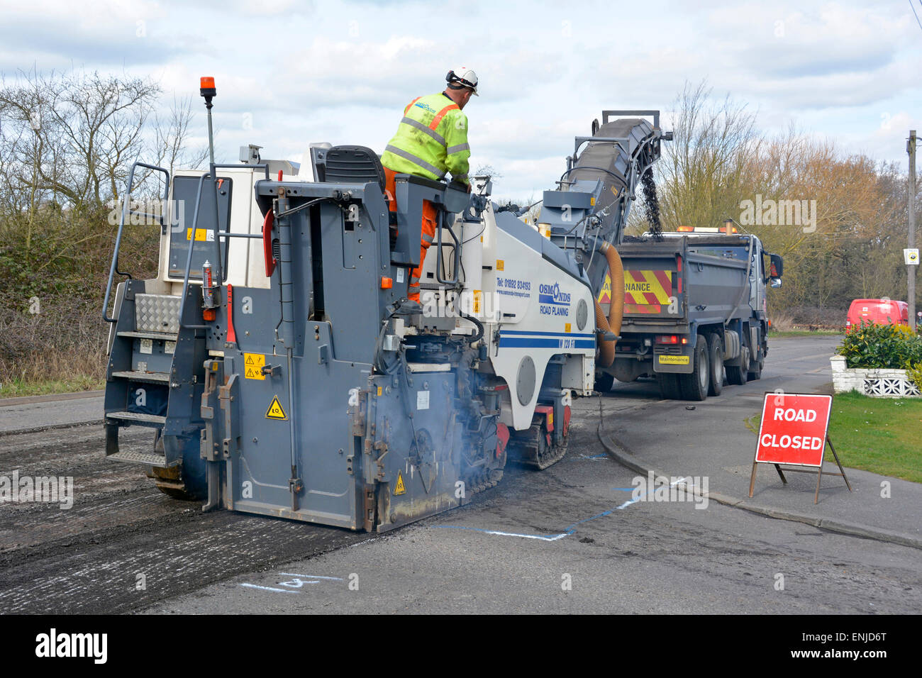 Defekte, abgenutzte Asphaltstraße wird abgefräst, um die Aufarbeitung von Kipper-Lkw-Ladeabfällen für das Recycling von Brentwood Essex England vorzubereiten Stockfoto