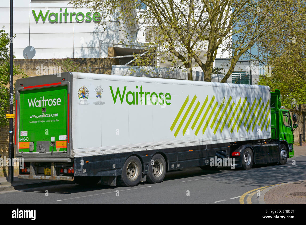 Wapping Waitrose Supermarkt Schild an der Außenwand mit artikulierten Lieferung LKW & Anhänger warten in der Straße East End von London England UK Stockfoto