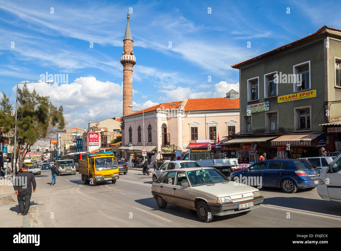 Izmir, Türkei - 7. Februar 2015: Esrefpasa Caddesi, Straßenansicht mit Moschee, Gebäudefassaden, Autos und zu Fuß normale Menschen Stockfoto