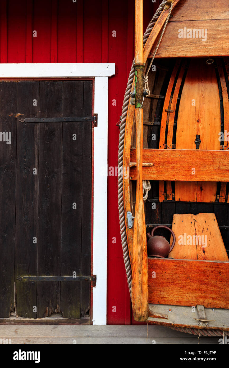 Rot, Schwedisch, costal Fischerhütte mit schwarzen Tür und hölzernen Ruderboot Stockfoto