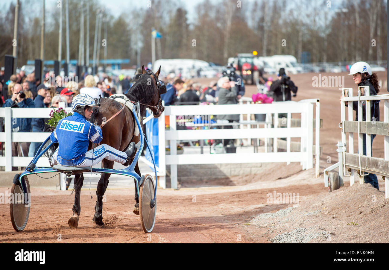 Erik Adielsson hinter Rand Boko in den Kreis der Sieger gewann das zweite Rennen in V75 in Mantorp am 18. April 2015. Stockfoto