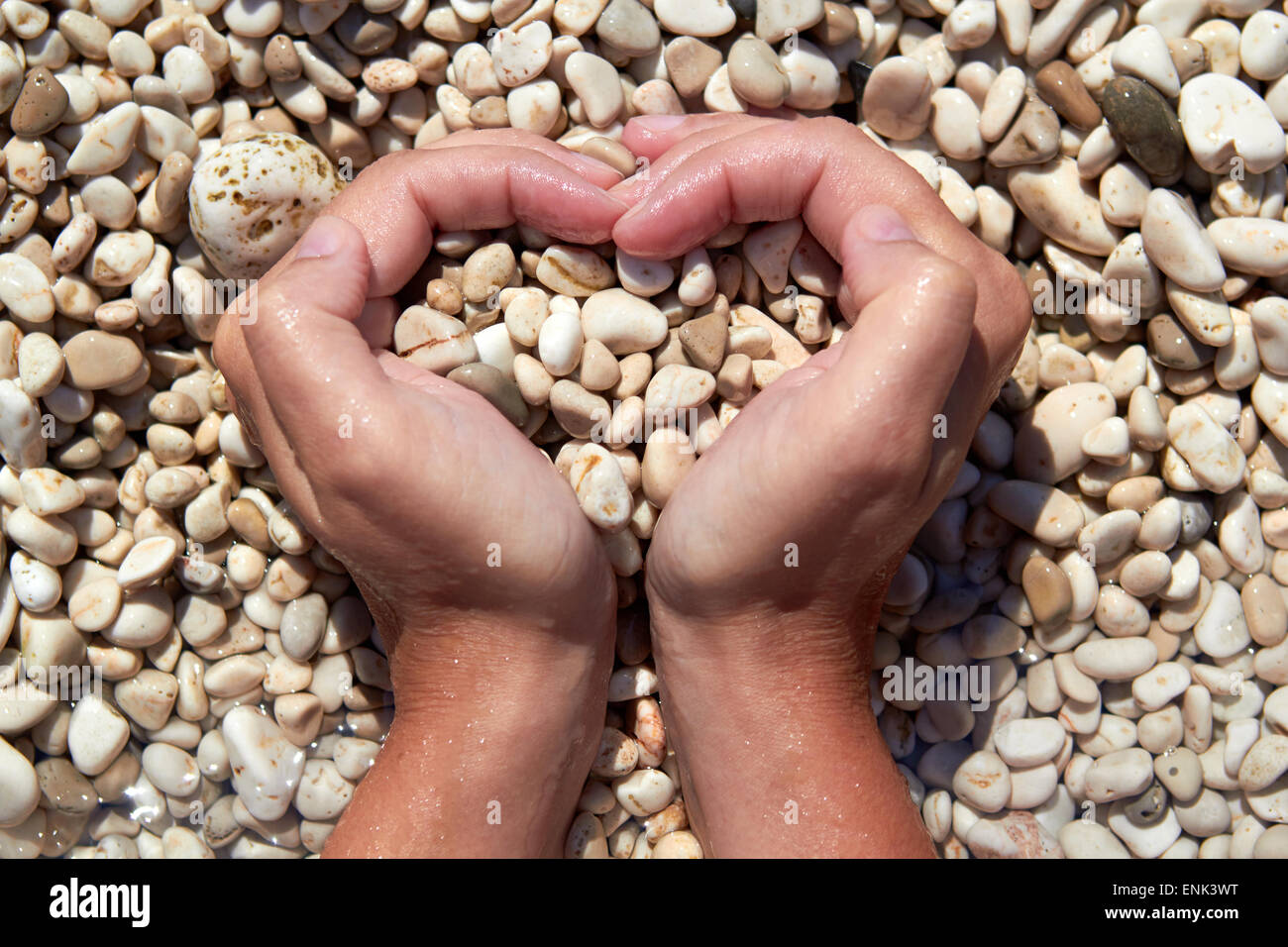 Hände in Form von Herzen mit Kieselsteinen im Inneren Stockfoto