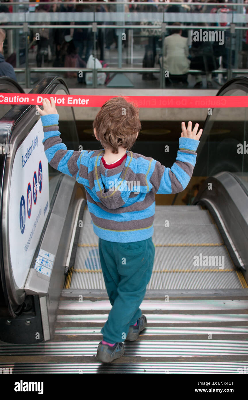 Junge auf Rolltreppe Stockfoto