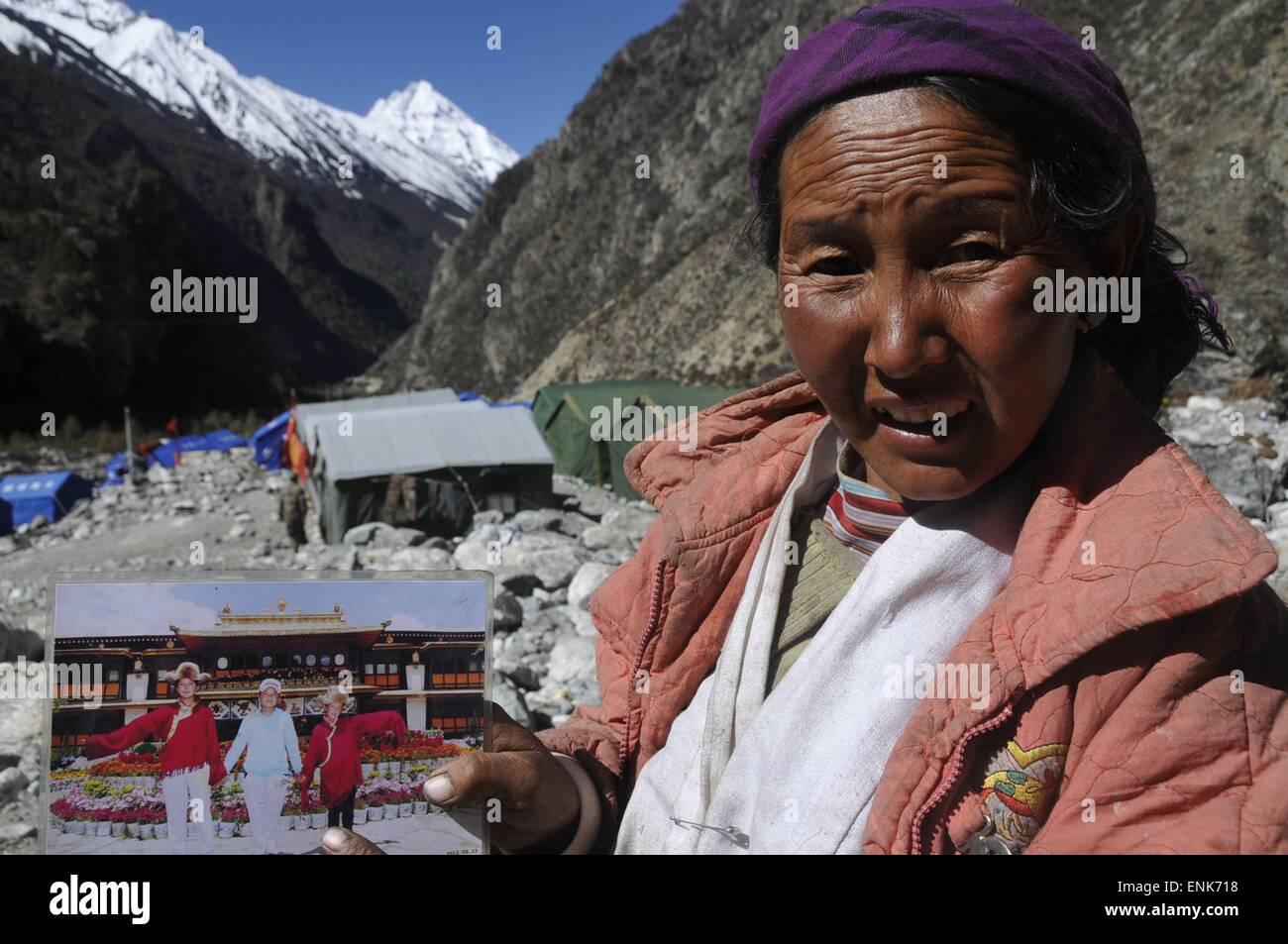 Tingri, China Tibet autonome Region. 4. Mai 2015. Eine Frau zeigt ein Foto von ihren Töchtern in einer Notunterkunft in Rongxia Township in Tingri, Südwest-China Tibet autonome Region, 4. Mai 2015. Mehr als 800 Menschen in Rongxia haben gut mit sicheren Lebensmitteln und Trinkwasser untergebracht worden. Die Region wurde schwer getroffen und von April 25 Erdbeben in Nepal. © Norbu Cering/Xinhua/Alamy Live-Nachrichten Stockfoto