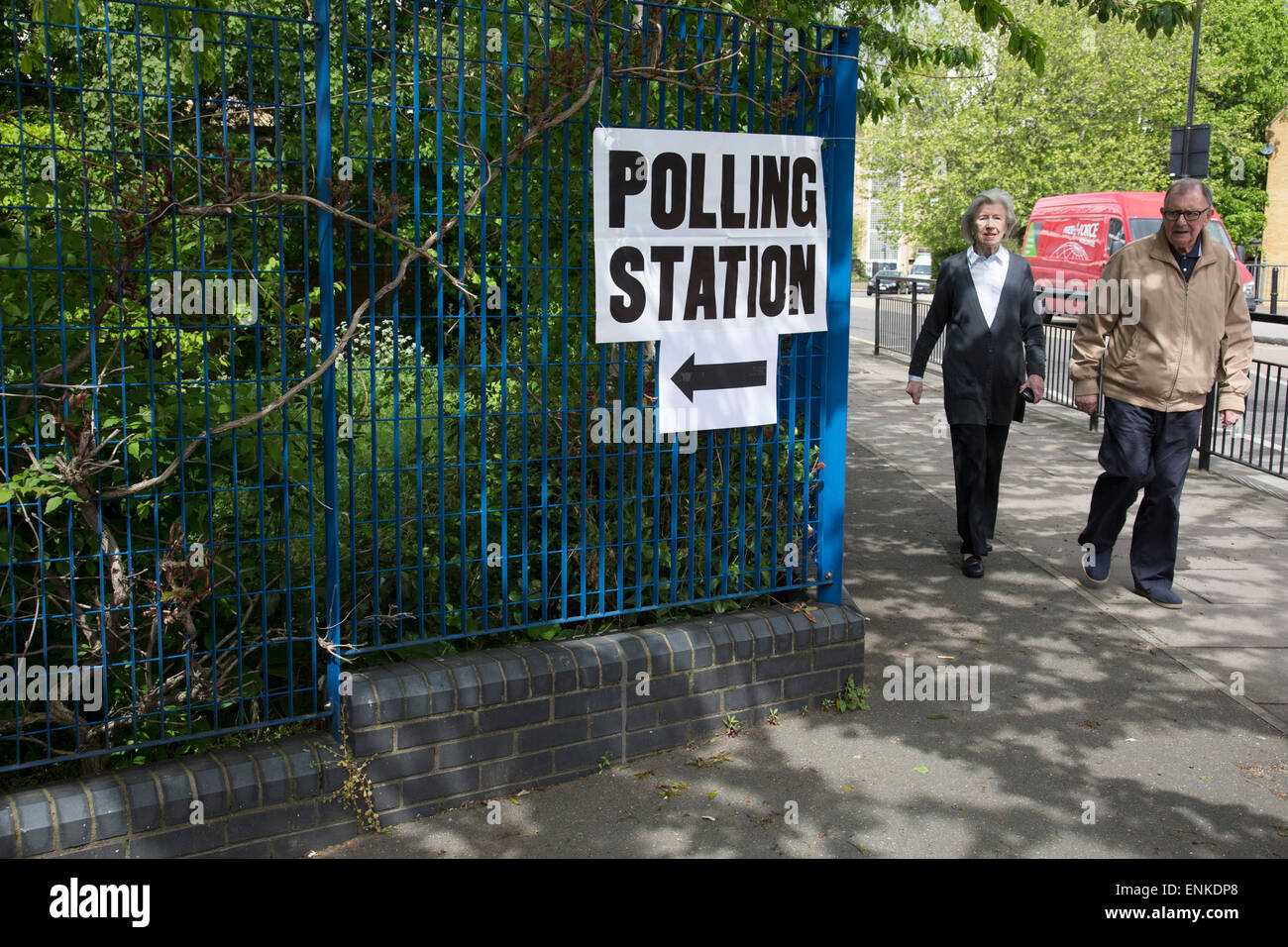 London, UK. Donnerstag, 7. Mai 2015. Wähler, die Teilnahme an einem Wahllokal in der Einsiedelei Primary School im Wahlkreis von Pappel und Limehouse in East London am Tag der allgemeinen Wahlen. Dies ist ein Labour-Partei Sitz, obwohl diese electin festgelegt ist, zu einem der am heftigsten umkämpften in einer Generation. Stockfoto