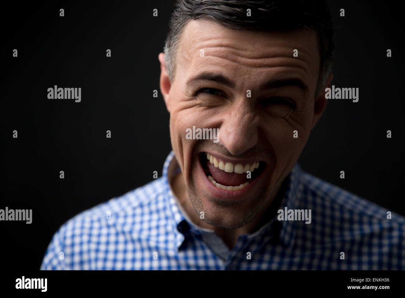 Porträt eines Mannes schreien über schwarzen Hintergrund und Blick in die Kamera Stockfoto