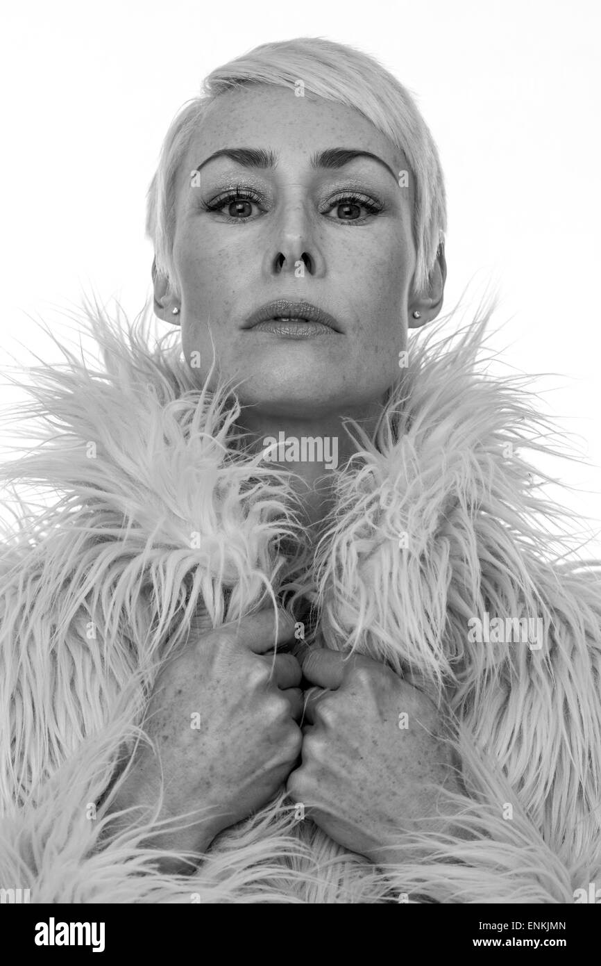 Reife Frau mit kurzen blonden Haaren nach unten ihre Nase Stockfoto