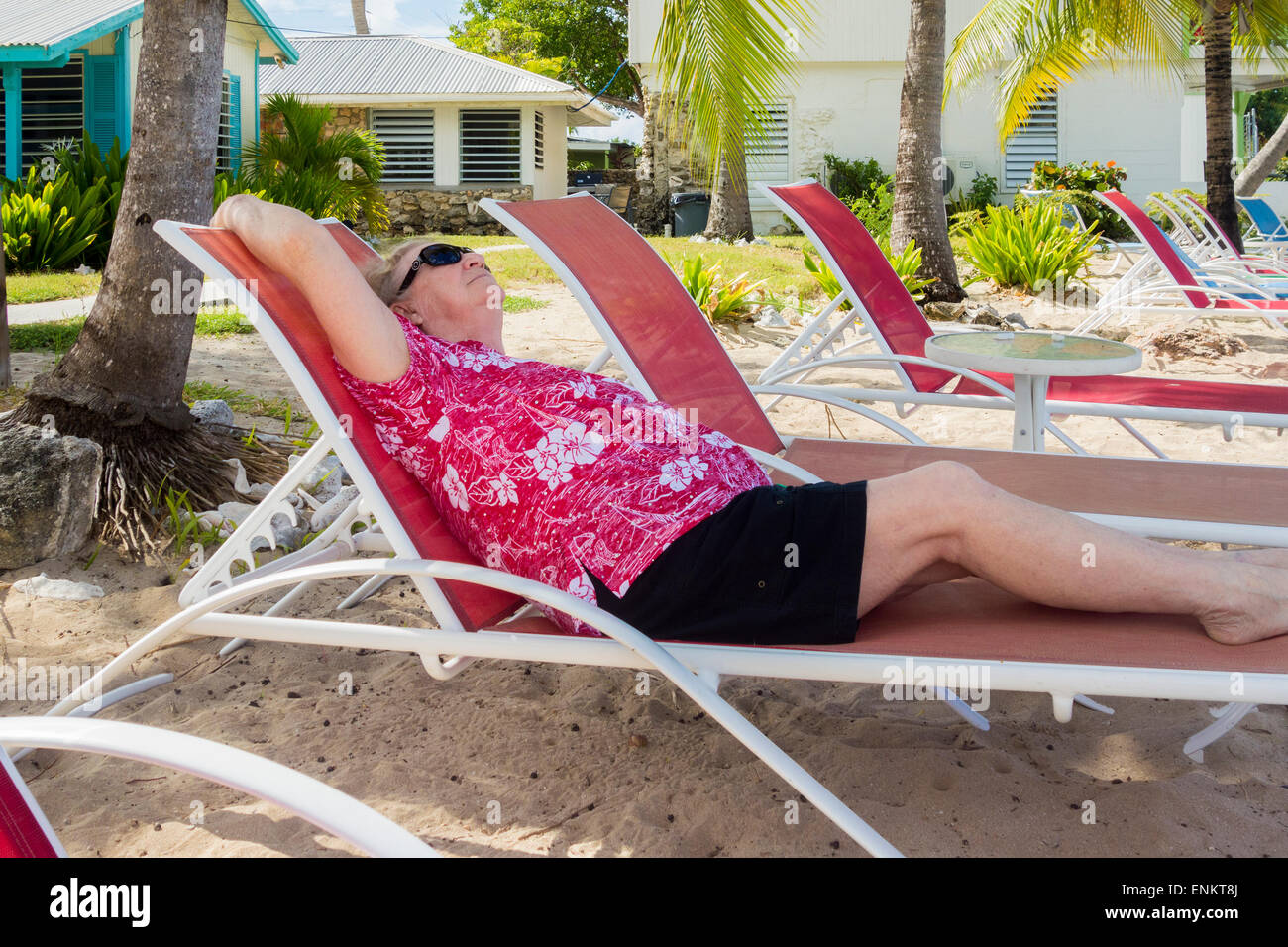 Eine ältere Frau genießt liegen in einem Strandkorb in einem Resort in der Karibik. St. Croix, U.S. Virgin Islands. Cottages by the Sea Resort. Stockfoto