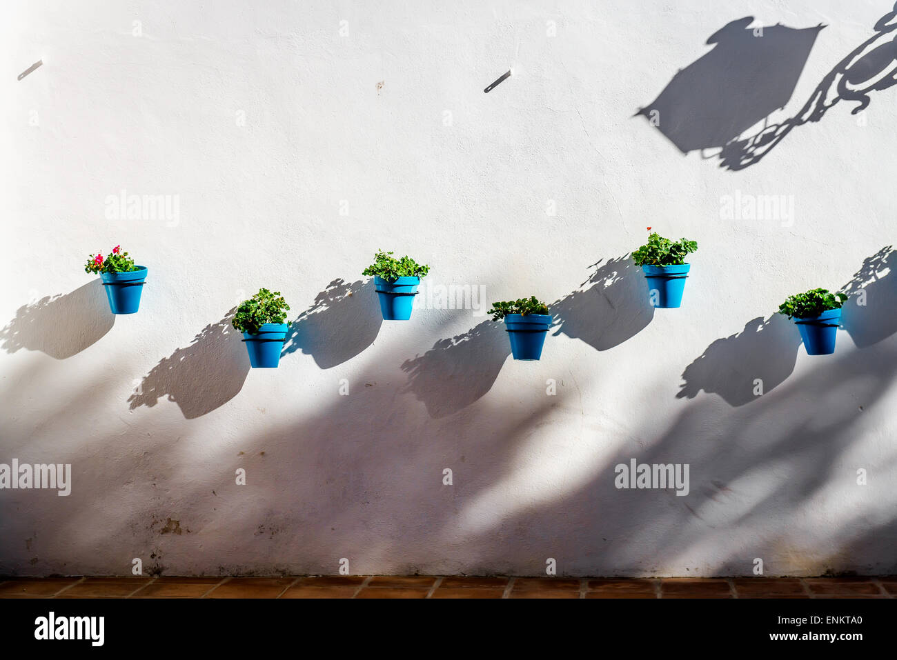 Blaue Blumentöpfe auf einer weißen Wand in Mijas Stockfoto