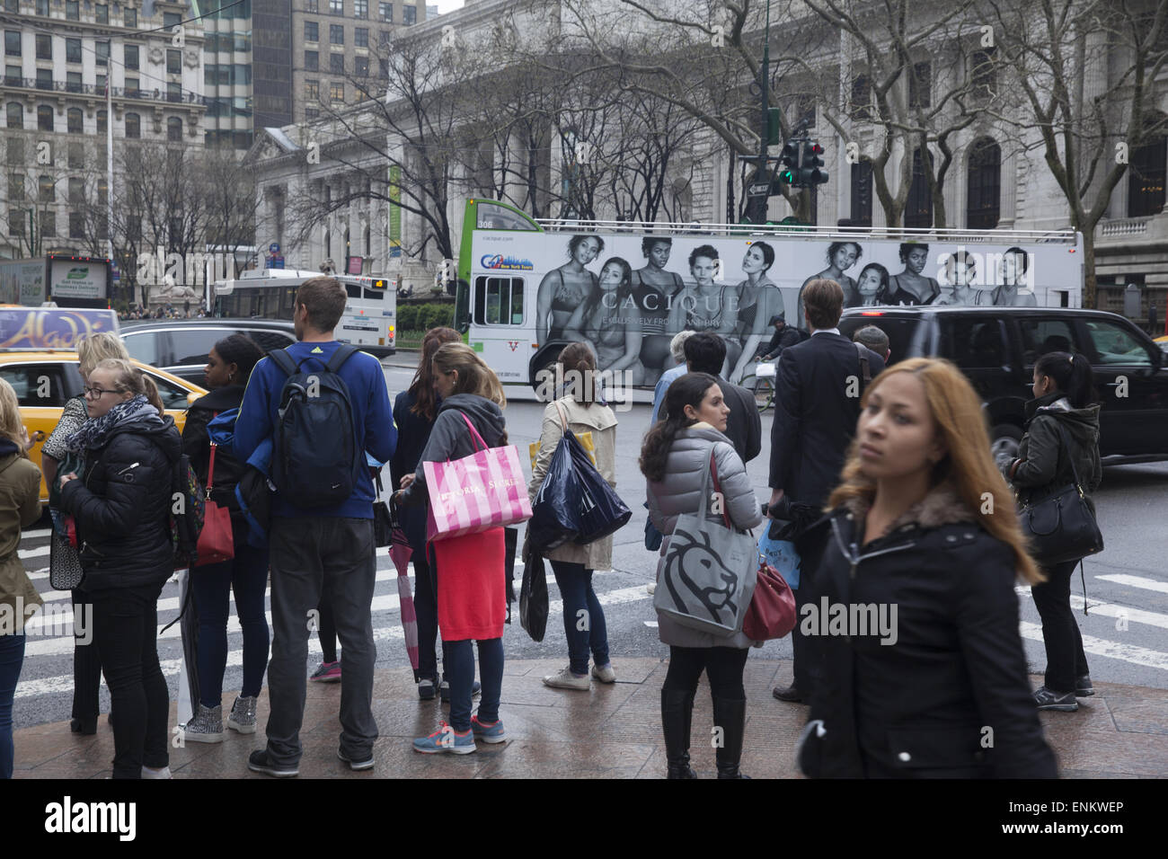 Fußgänger warten 42nd St. an der 5th Ave mit der New York Public Library im Hintergrund zusammen mit einem beweglichen Bus Werbung zu überqueren Stockfoto Fußgänger warten 42nd St. an der 5th Ave mit der New York Public Library im Hintergrund zusammen mit einem beweglichen Bus Werbung zu überqueren Stockfoto