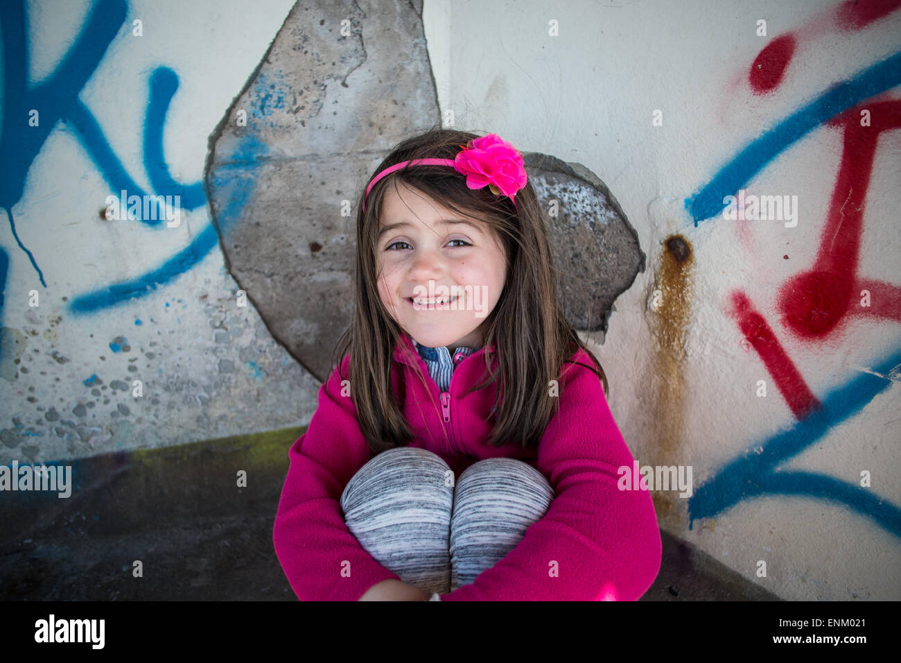 kleines Mädchen saß Graffitiwand Weston super Mare Stockfoto