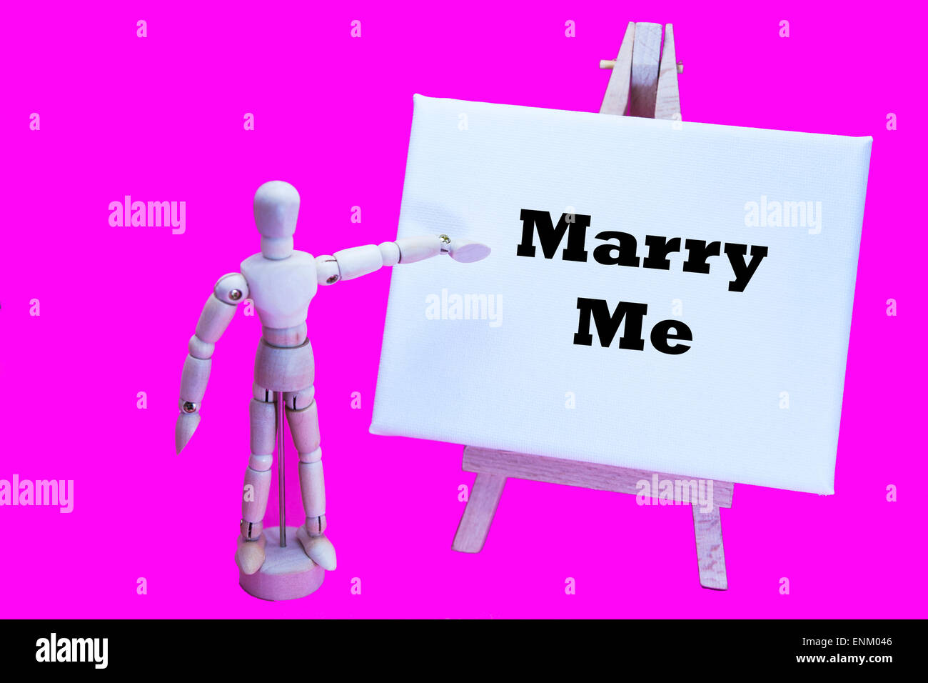 Hölzerne Mann mit weißen Tafel zeigt auf Worte "Marry Me" Vorschlag schlägt vor Erklärung der Liebe Ehe Fragen Fragen Stockfoto