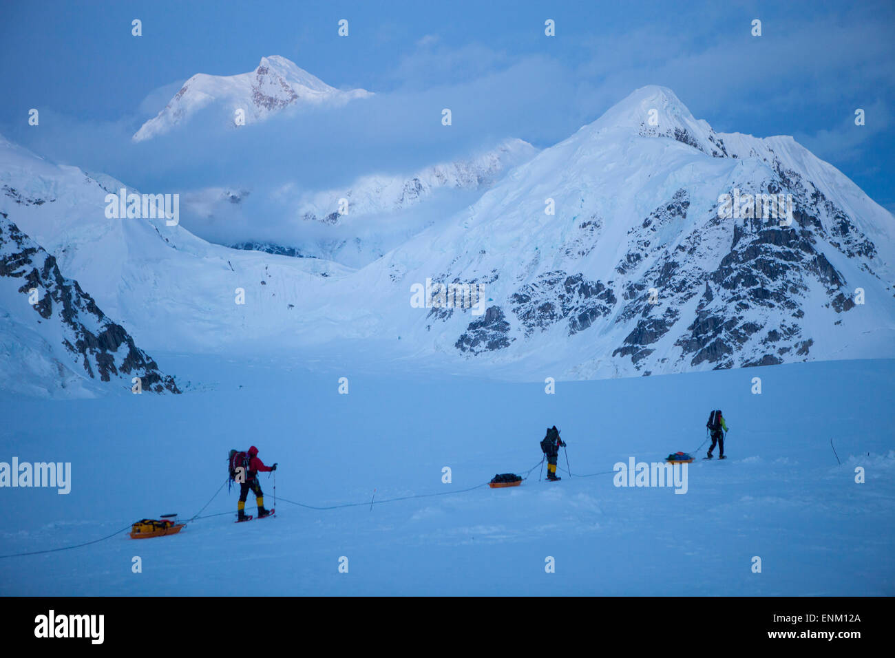 Ein Team von drei Bergsteiger auf ihrem Weg ins Basislager nach erreichen des Gipfels des Mount McKinley, auch bekannt als Denali in Alaska. Mount Hunter im Hintergrund. Stockfoto