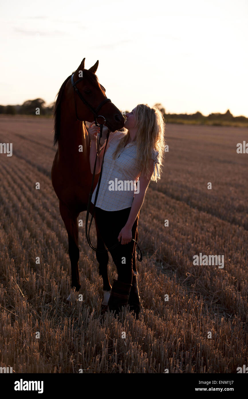 Eine junge Frau, die nach oben auf ein Arabisches Pferd Stockfoto