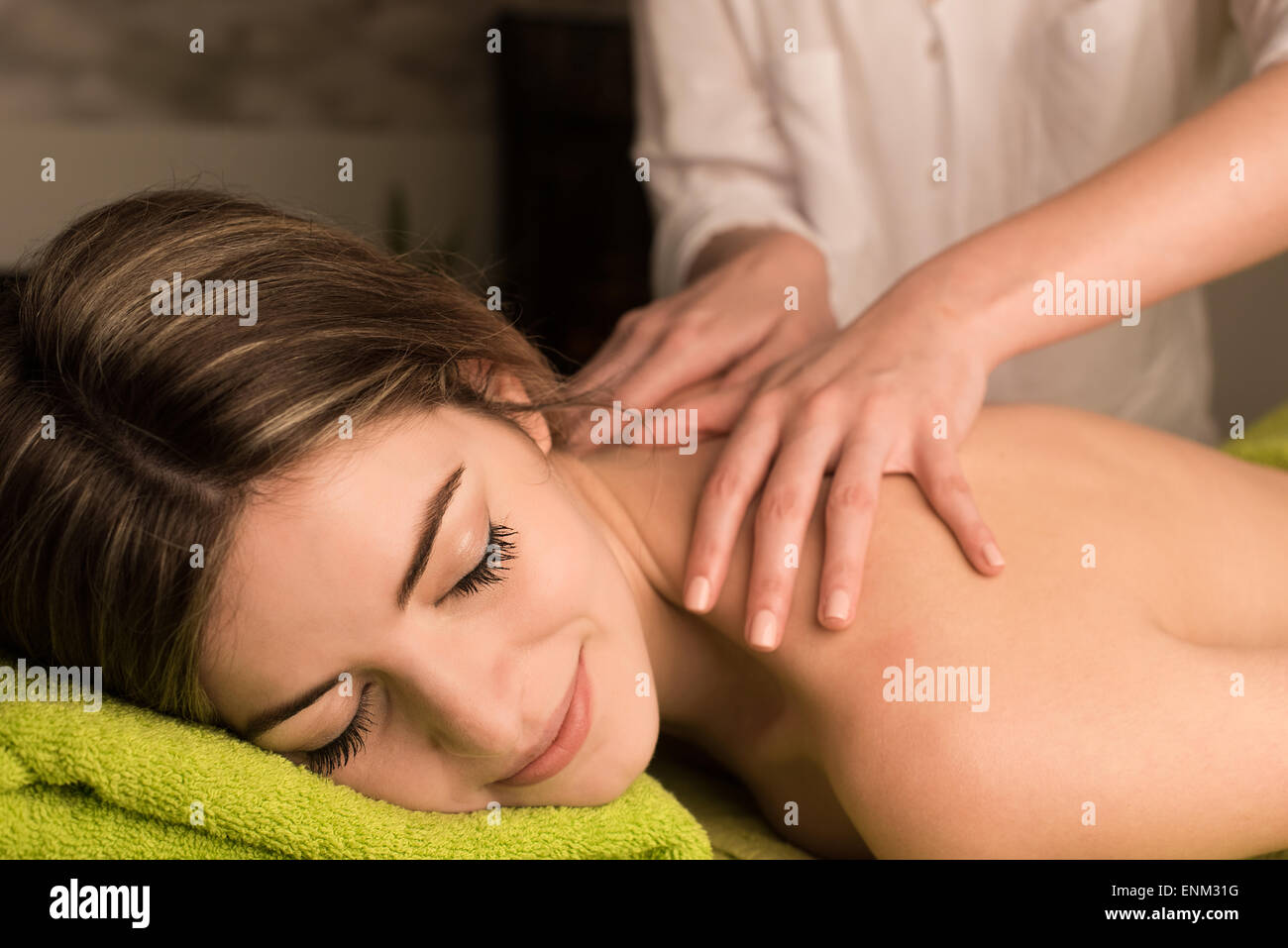 Junge Frau, die eine Rückenmassage im Wellnessbereich Stockfoto