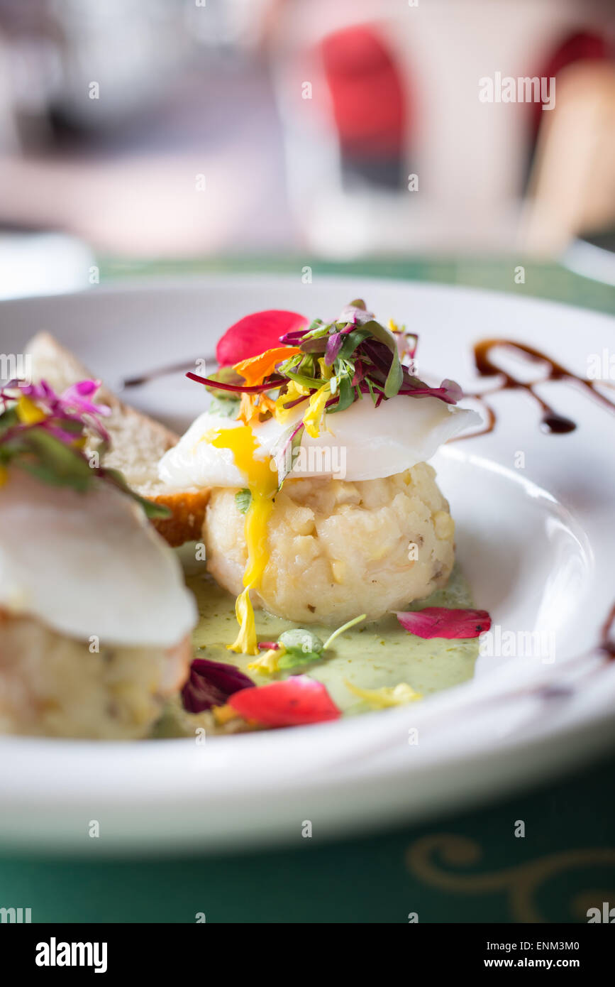 Pochiertes Ei auf Kartoffelpüree Ball in eine Avocado Sauce Hollandaise mit Garnierung Mikro-grün Stockfoto