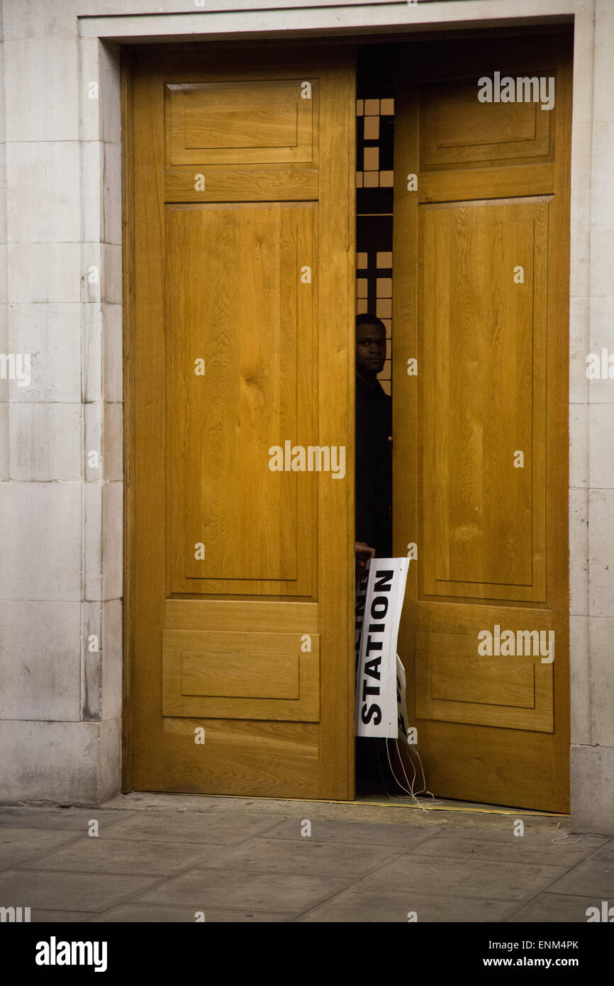 Hackney, London, UK. 7. Mai 2015. Nach einem langen Tag der Abstimmung über die das Land bei den Parlamentswahlen die Wahllokale schließen. Ein Wahllokal Offizier in Hackney Town Hall kuppelt die Beschilderung kurz nach 22:00 Credit: Kristian Buus/Alamy Live News Stockfoto